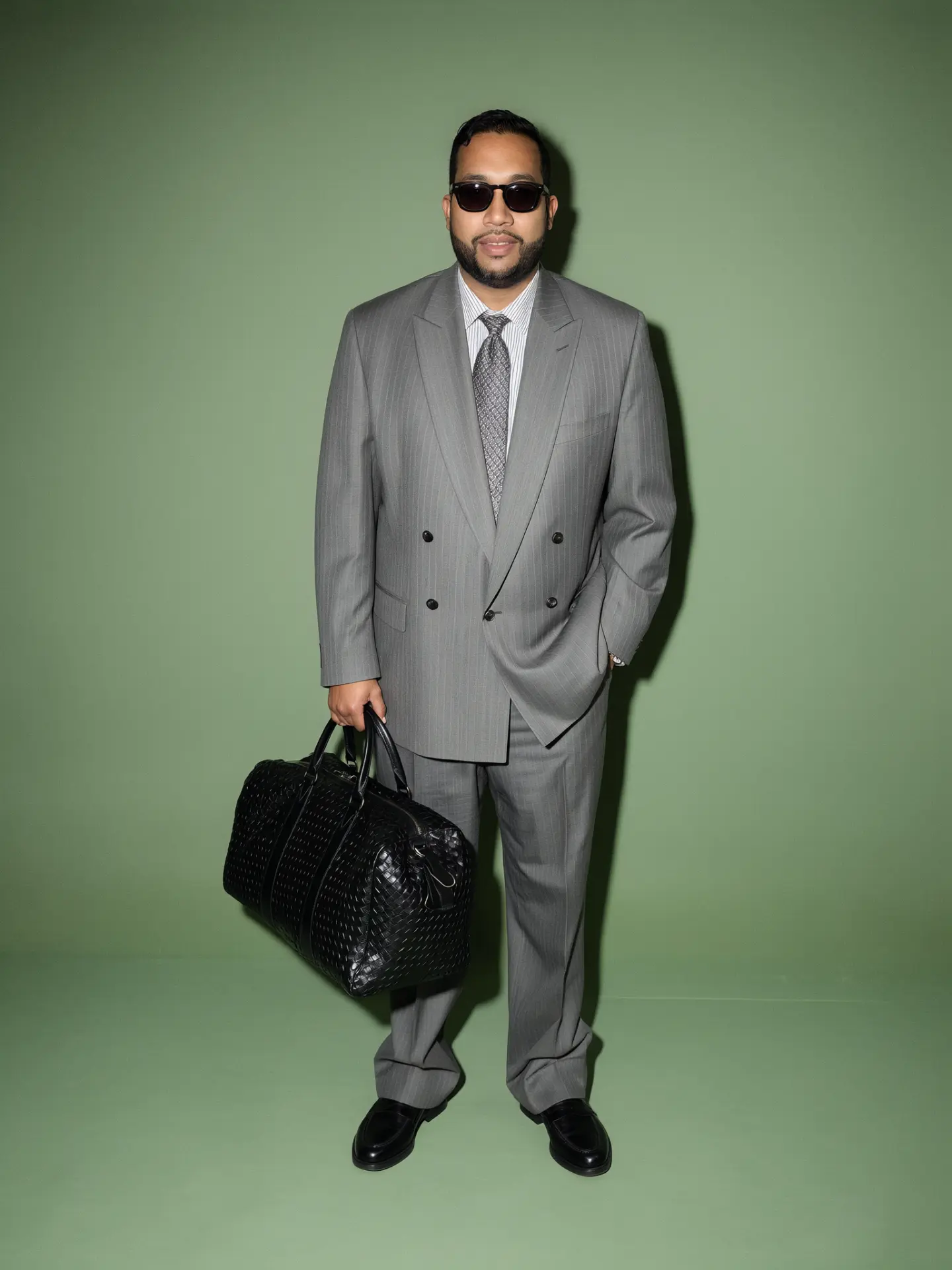 Dr. D standing in a grey pinstripe suit